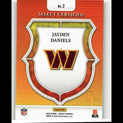 This is a 2024 panini select football trading card featuring jayden daniels with the washington commanders logo, designed in an orange and gold shield motif.