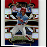 Red helmeted baseball player in a light blue jersey and white pants, captured mid-swing on a glossy trading card with gold trim.