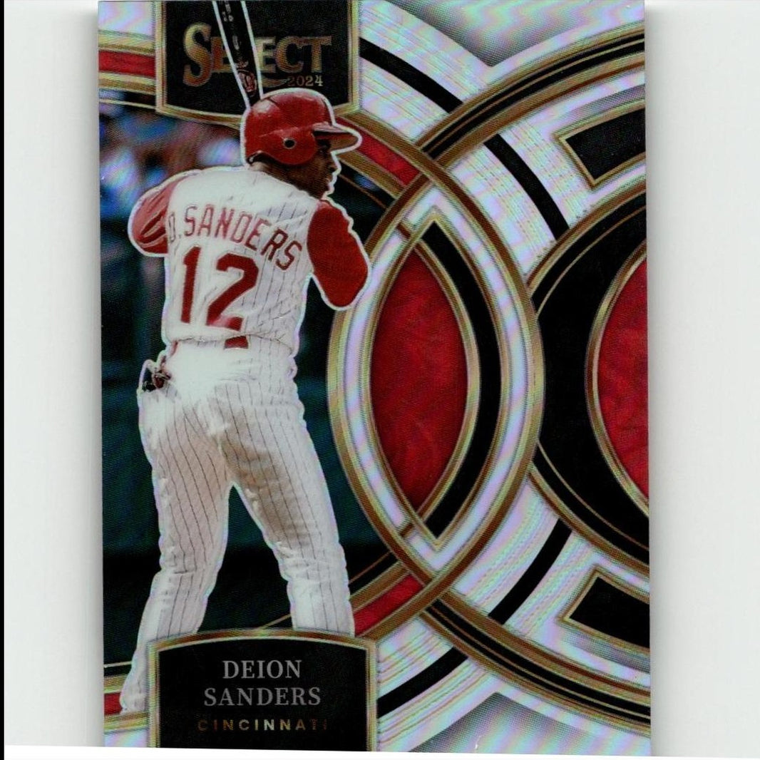 A 2024 select baseball trading card featuring deion sanders in a white pinstripe uniform with red accents and helmet, set against an ornate silver, black, and red geometric background.