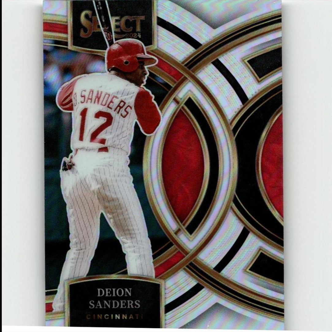 A 2024 select baseball trading card featuring deion sanders in a white pinstripe uniform with red accents and helmet, set against an ornate silver, black, and red geometric background.