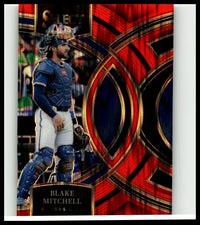 Blue and white baseball catcher’s uniform with protective gear featuring glossy red and black design on blake mitchell orange flash card