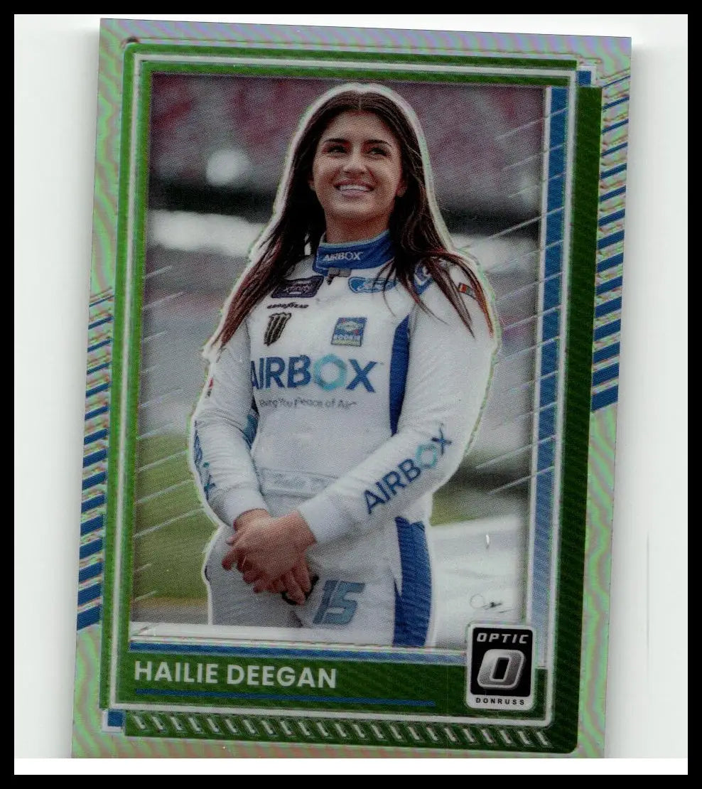 A green and blue holographic-bordered 2025 Donruss hailie deegan optic holo trading card featuring a smiling woman in a white airbox racing suit