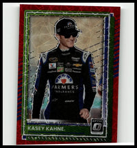 A red and green framed 2025 donruss kasey kahne optic red velocity trading card featuring kahne in black racing suit