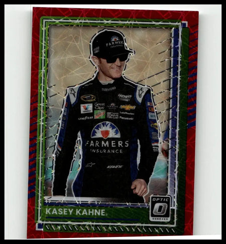 A red and green framed 2025 donruss kasey kahne optic red velocity trading card featuring kahne in black racing suit