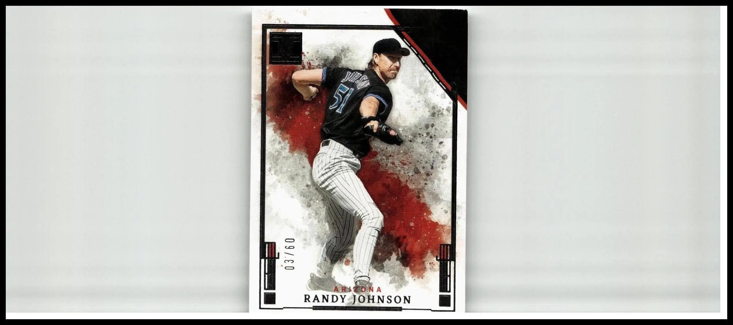 Black and white 2025 panini impeccable randy johnson silver baseball card featuring dynamic pitching pose with red splatter