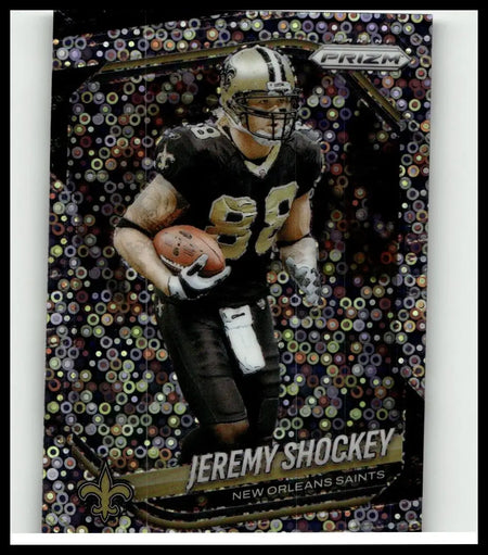 A shimmering black and gold 2025 panini prizm football trading card of jeremy shockey in new orleans saints uniform with prismatic background
