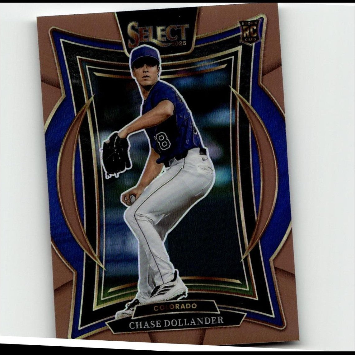 Bronze and blue framed baseball trading card featuring chase dollander in a colorado rockies uniform.