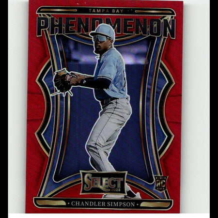 Red and blue tampa bay phenomenon baseball trading card featuring chandler simpson in a light blue jersey, gray pants, white cap with visor, black batting gloves, and gold-trimmed design elements.