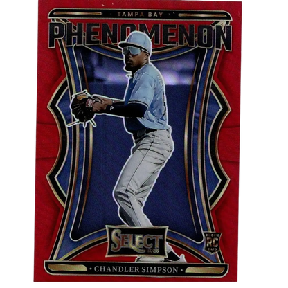 Red and blue tampa bay phenomenon baseball trading card featuring chandler simpson in a light blue jersey, gray pants, white cap with visor, black batting gloves, and gold-trimmed design elements.
