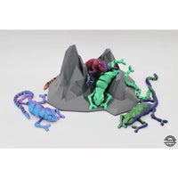 Articulated chameleon figurines on a geometric rock.