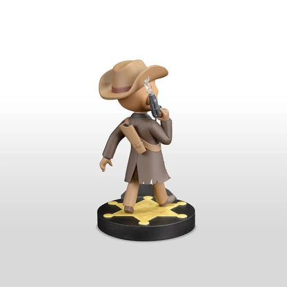 Tan cowboy figurine with a brown hat and coat, holding a silver revolver, standing on a black base with a gold star design.