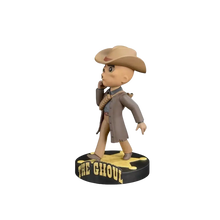 Tan cowboy-themed bobblehead figure wearing a brown hat and coat, standing on a black circular base with ’the ghoul’ in yellow lettering.