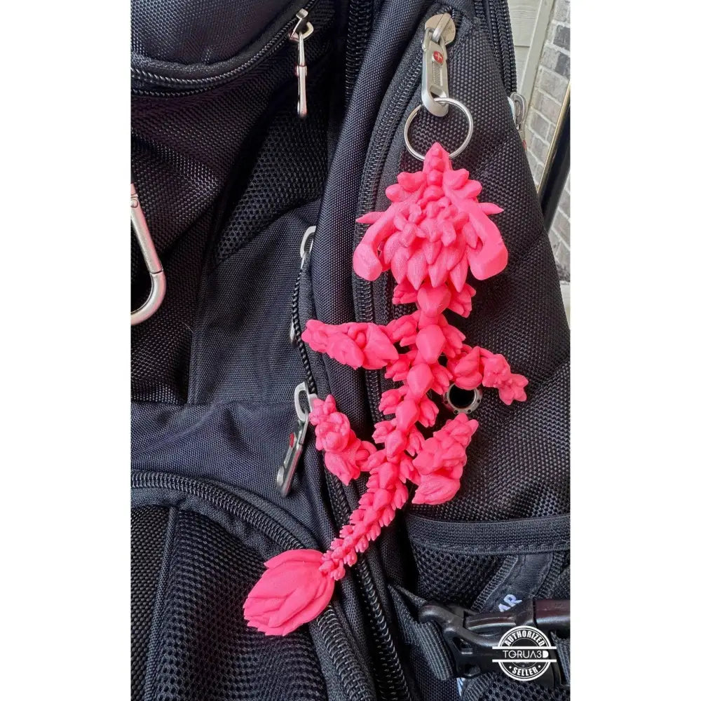 Pink 3D-printed dragon keychain.