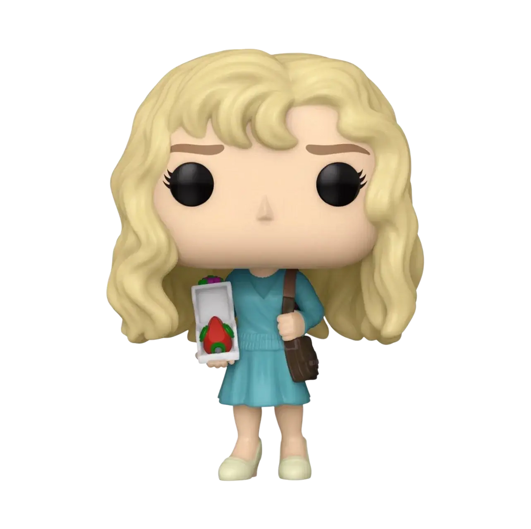 A blonde-haired funko pop! Figure dressed in a teal dress, holding an open box with a red strawberry inside and carrying a brown shoulder bag.