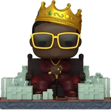 Funko pop action figure of the notorious big in red attire with a golden crown and yellow sunglasses holding a cane
