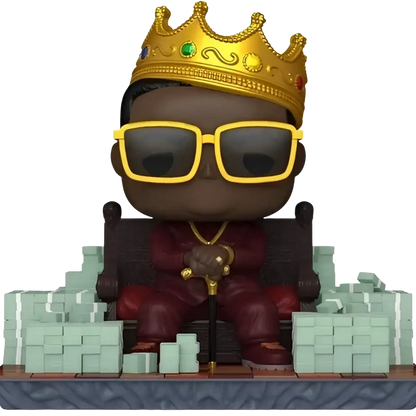 Funko pop action figure of the notorious big seated in red attire with yellow sunglasses and a golden crown holding a cane
