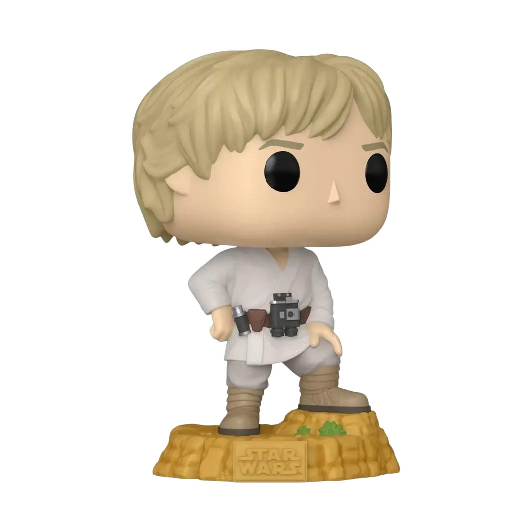 A blonde-haired luke skywalker funko pop figure in a white jedi robe with brown boots, standing on a textured desert base.