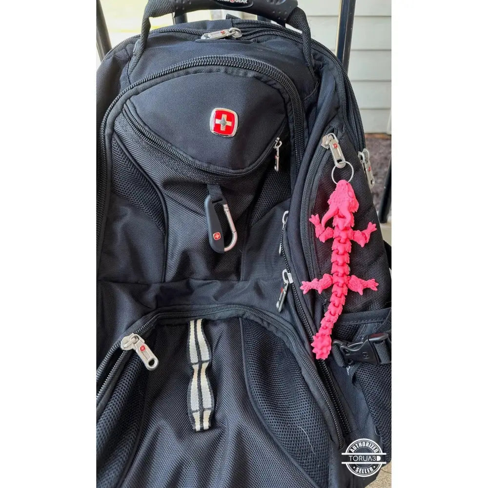 Black backpack with pink lizard keychain.