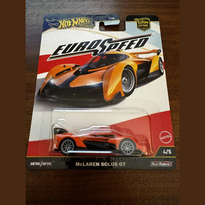 Hot wheels mclaren solus gt model car, metallic orange and black design with silver wheels.
