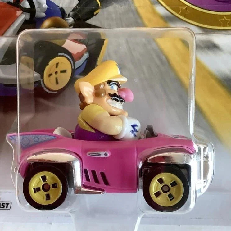 Pink and yellow wario toy car with gold wheels, packaged in clear plastic.