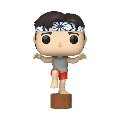 Karate Kid Daniel Crane Kick Funko Pop #2080 by Funko balancing on one leg on a wooden stump in his iconic pose.