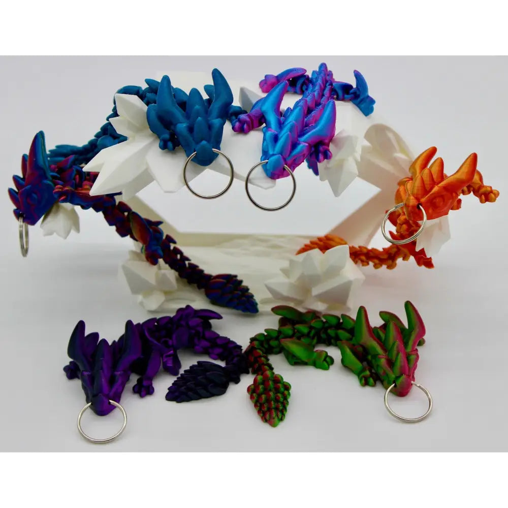 Colorful dragon keychains on a white stand.