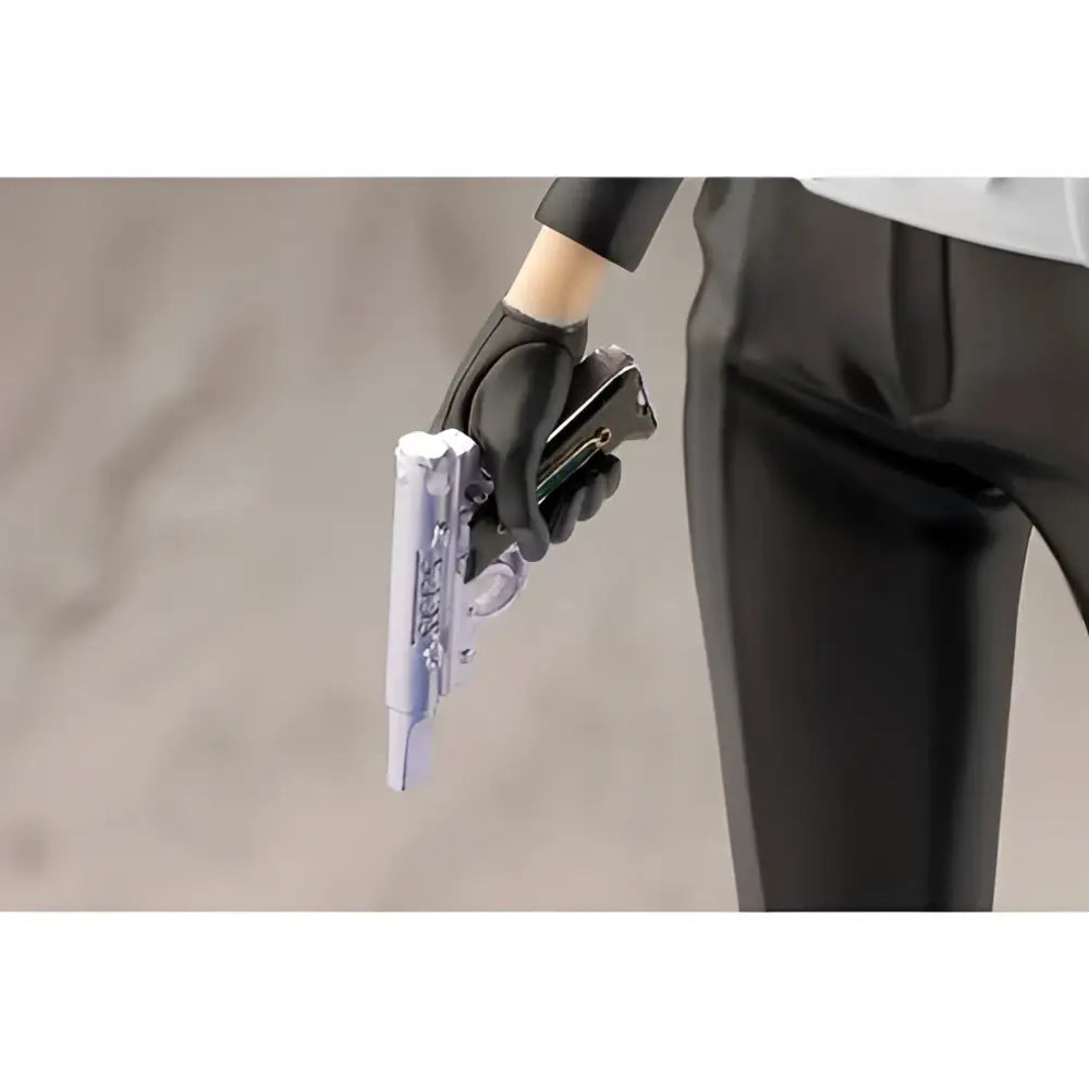 A translucent silver pistol with intricate detailing held in a black-gloved hand from persona 3 reload artfx statue