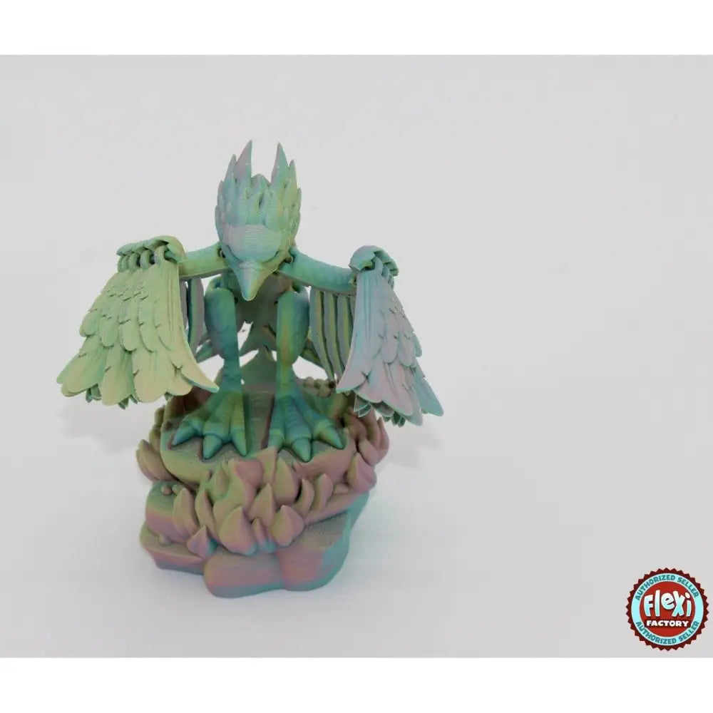 Iridescent bird statue on a rocky base.