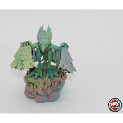 Iridescent bird statue on a rocky base.