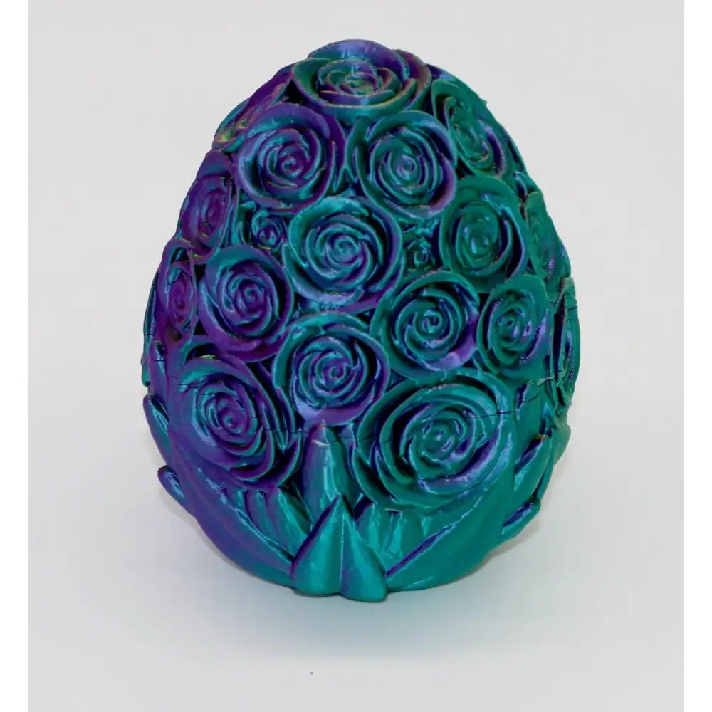 Egg-shaped rose sculpture with iridescent purple and teal finish.