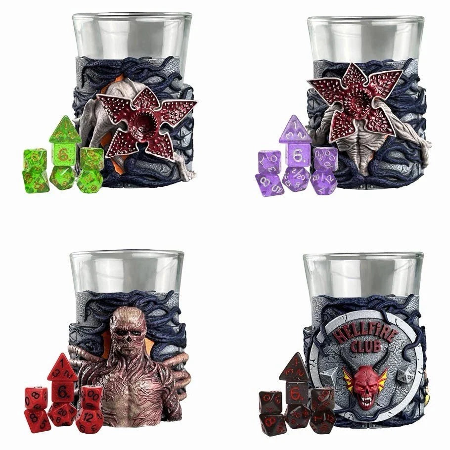 The image displays four distinct themed shot glasses, each featuring a unique horror-inspired design with accompanying polyhedral dice in matching colors and patterns.