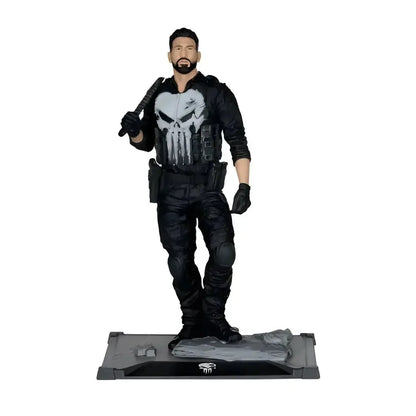 The punisher 1 10 scale posed figure features a black tactical gear action figure with a white skull emblem on a rocky base