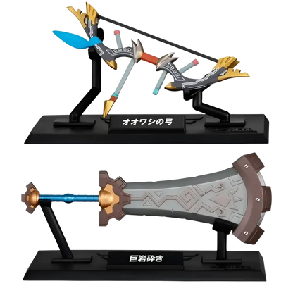 The ’ōō no tsukihime’ and ’ōyakashi’ sword figurines from the bandai gashapon collection, featuring detailed metallic finishes with gold accents on their hilts and blades.